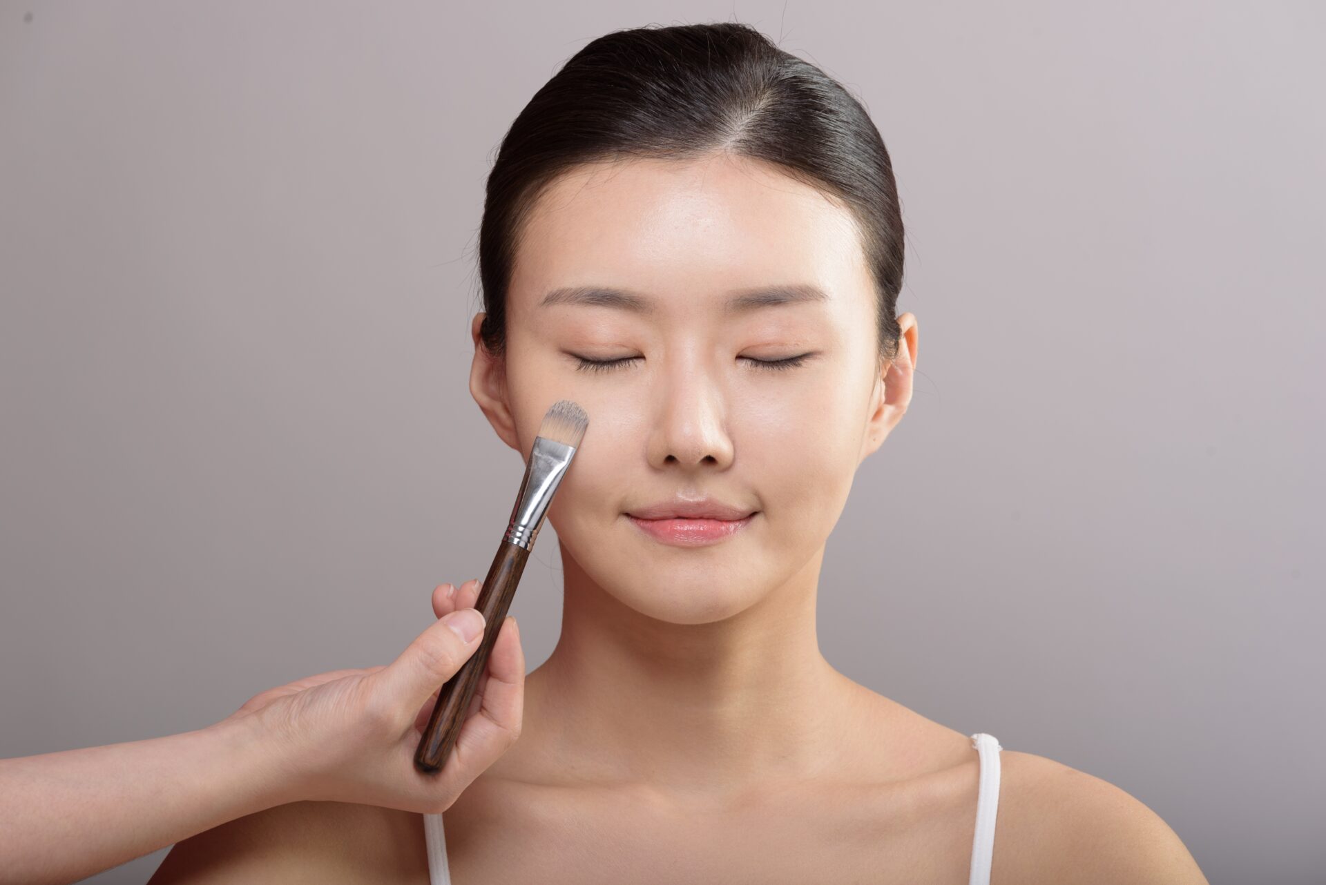 コンプレックスを隠すためにメイクをする女性