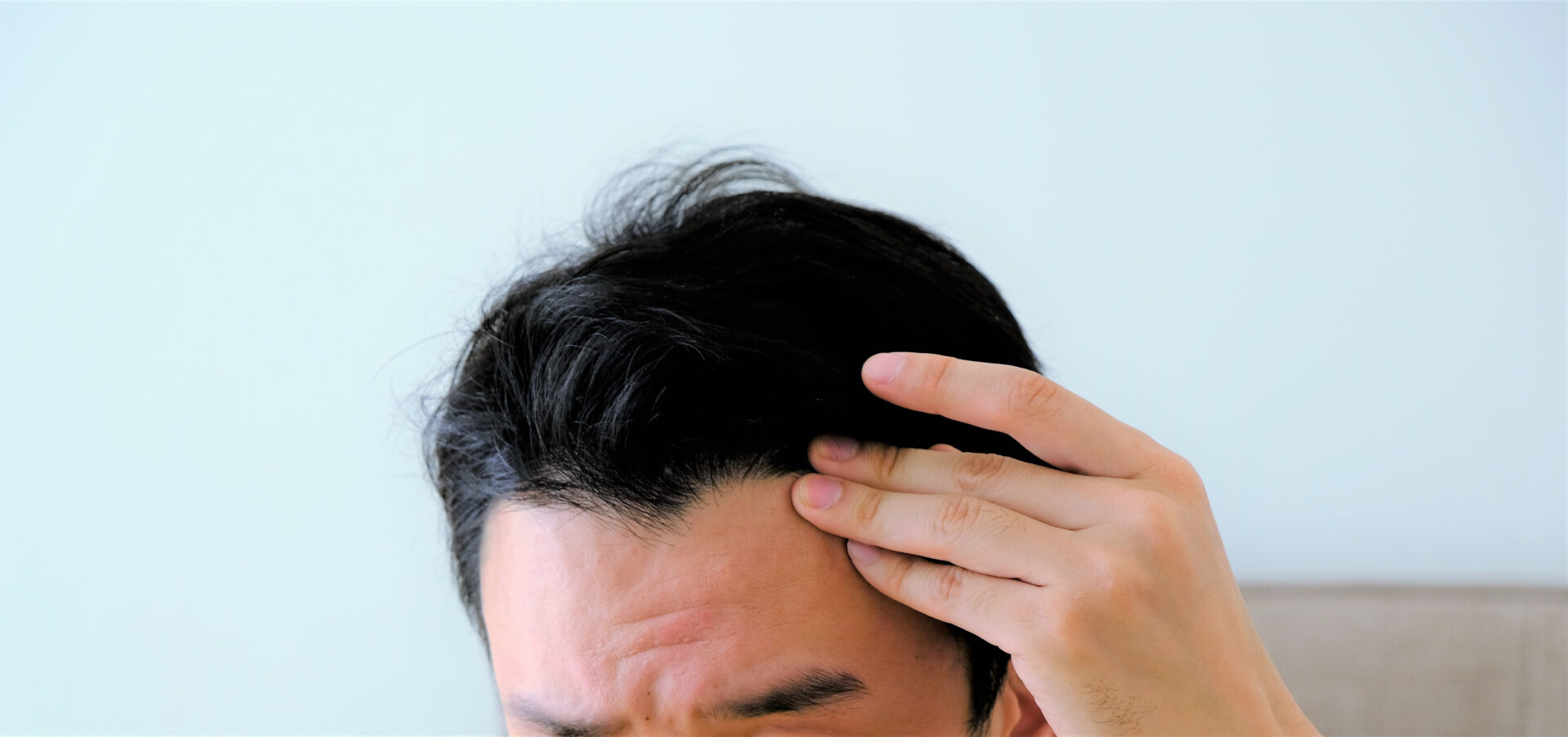 額を押さえる男性